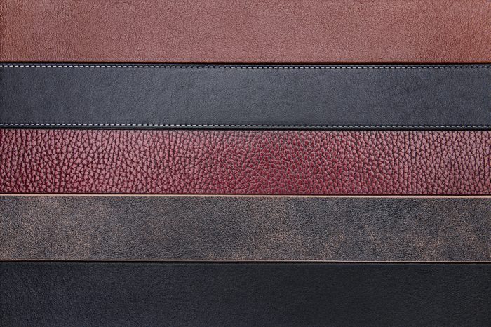 Dark natural leather belts close-up texture background