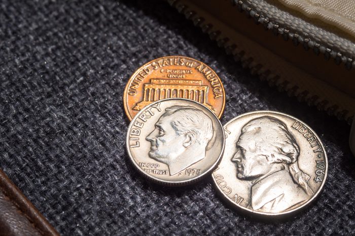 US dollar coins placed outside the wallet.