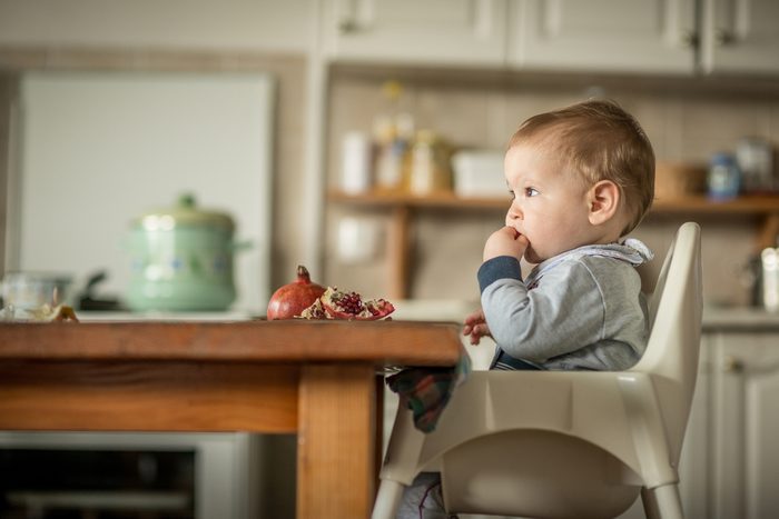 Portrait Of Happy Young Baby Boy In High Chair