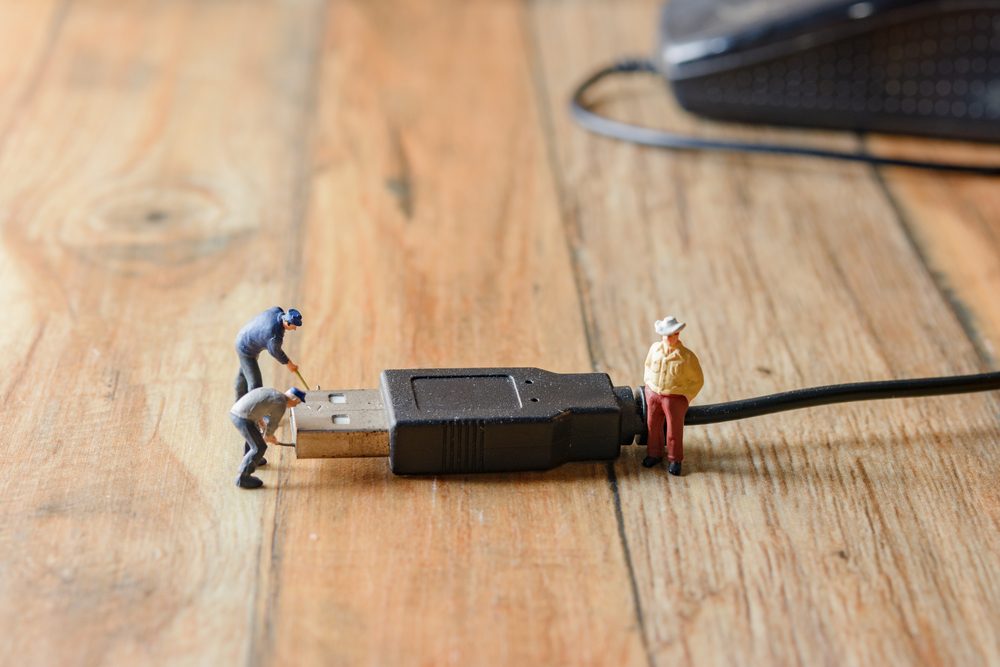 computer mouse and miniature worker repair fix on wood table