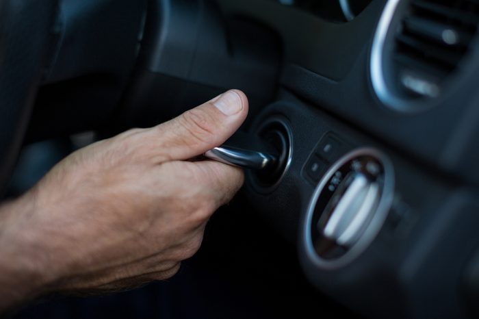 Cropped hand of person starting car