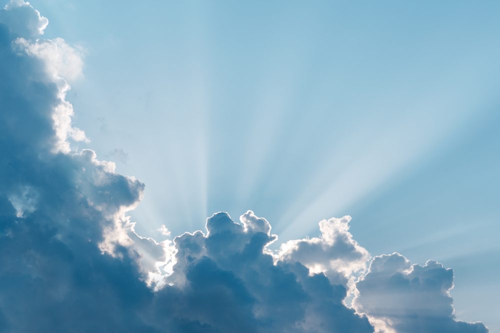 Surreal sun rays are striking through the clouds like an explosion.