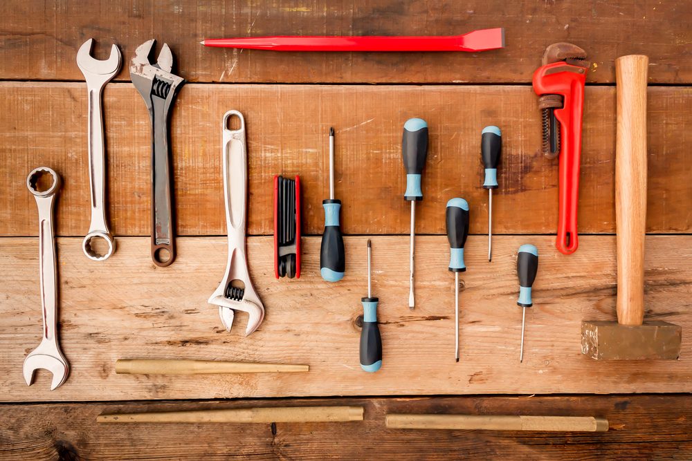 Hand tool complete set the Wrench, screwdriver, Phillips screwdriver, flat crowbar,brass hammer,pipe wrench,punch,Hex wrench on wood background.