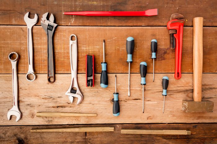 Hand tool complete set the Wrench, screwdriver, Phillips screwdriver, flat crowbar,brass hammer,pipe wrench,punch,Hex wrench on wood background.