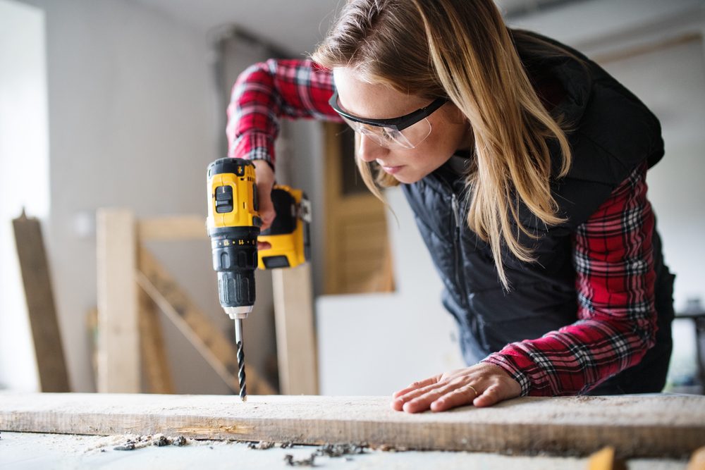 Young woman worker in the carpenter workroom.