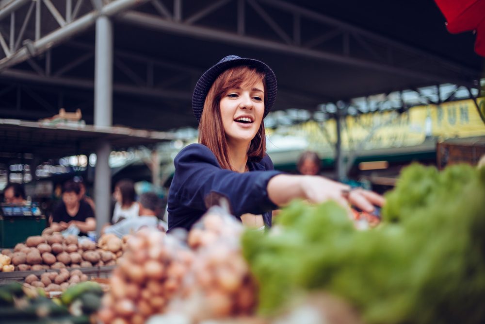 Young Female Looking For Some Vegetables At Market Place