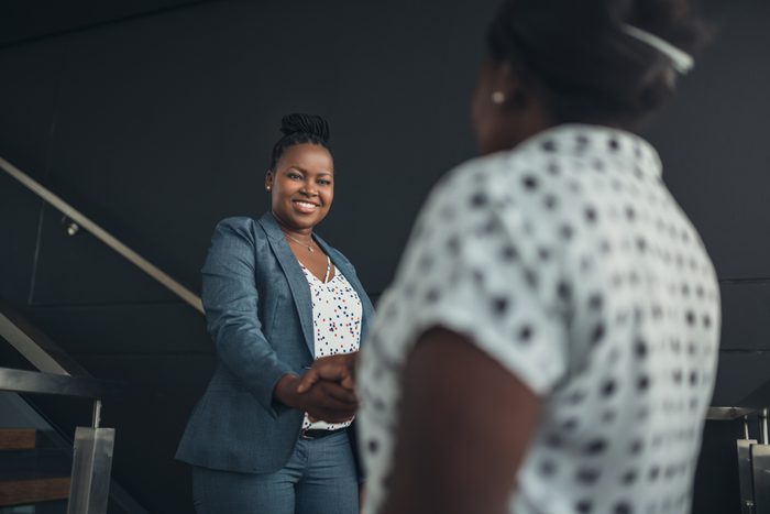 Executive african american woman shaking hands with welcoming smile