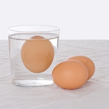 Rotten egg, salmonella risk. Old fashioned test. Bad egg floats in glass of water.; Shutterstock ID 429271258; Job (TFH, TOH, RD, BNB, CWM, CM): TOH Egg Freshness Test