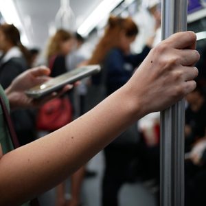 closeup woman hand holding handrail inside the train.