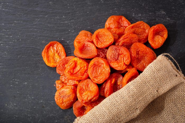 dried apricots on dark table, top view