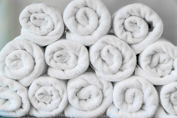 Blurred bathroom interior background and white spa towels on wood.