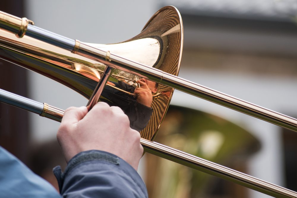 trombone player from a brass orchestra with reflection in the music instrument