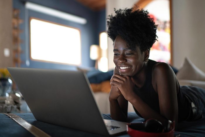 woman watching tv on her computer at home