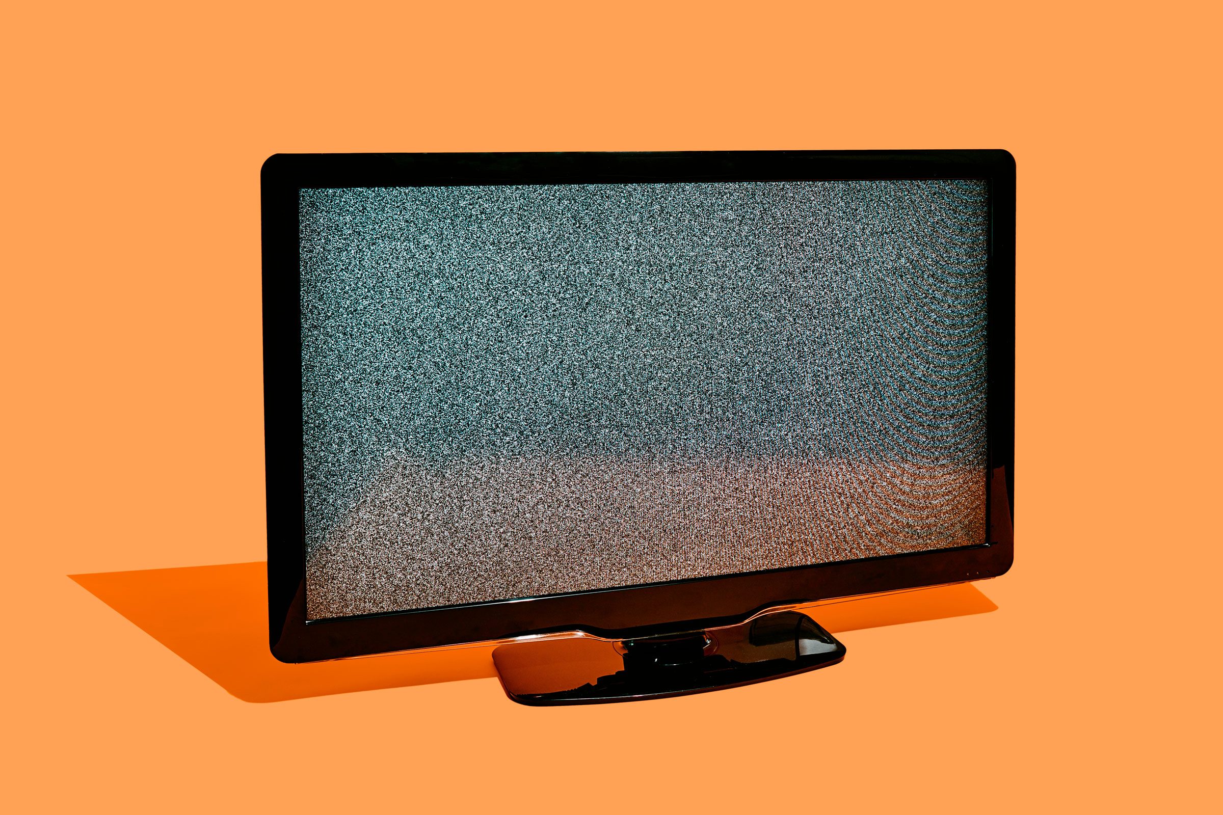 Static flat screen TV on an orange background