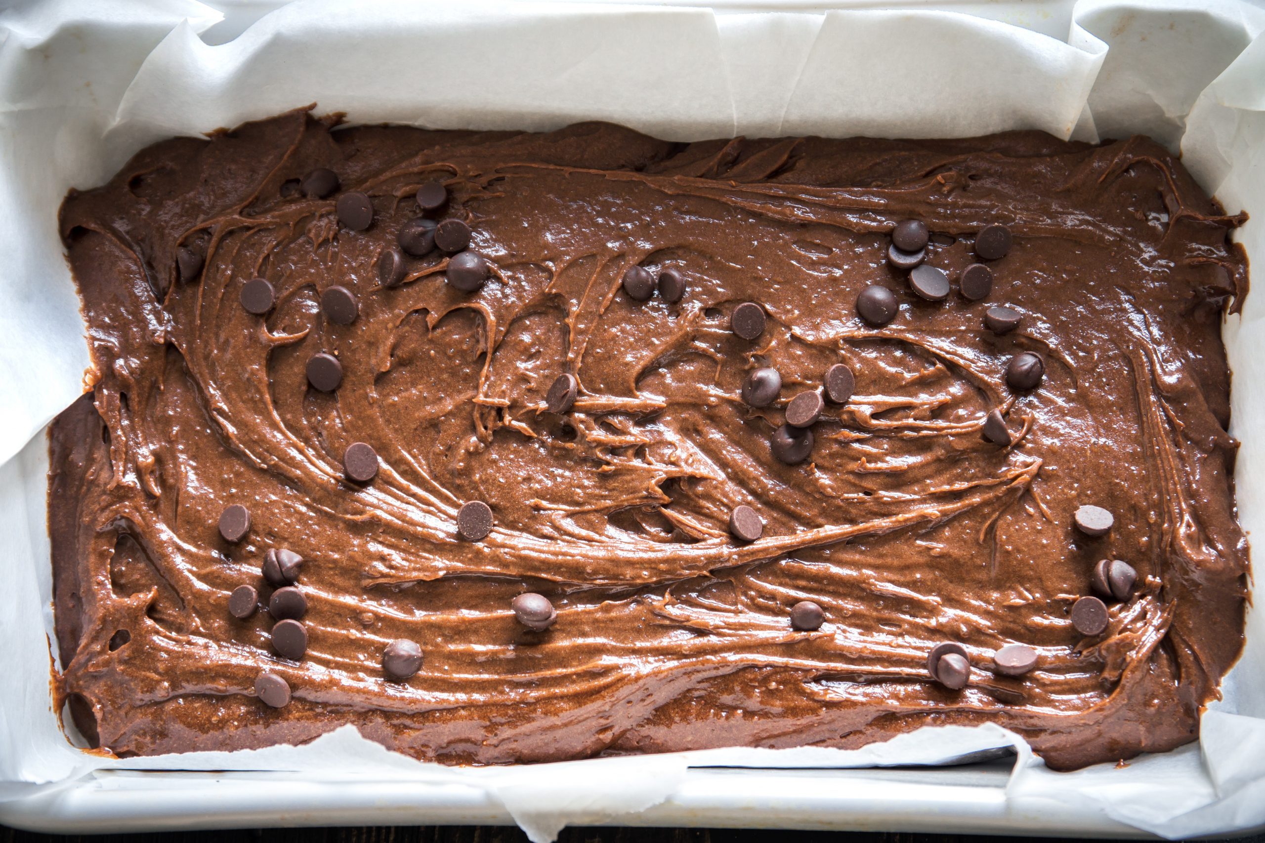 Basic homemade brownie or chocolate cake raw dough in baking pan. Cooking (baking) homemade chocolate cake or brownie.