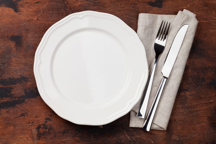 Table setting. Empty plate, knife, fork and napkin. Top view and flat lay with copy space