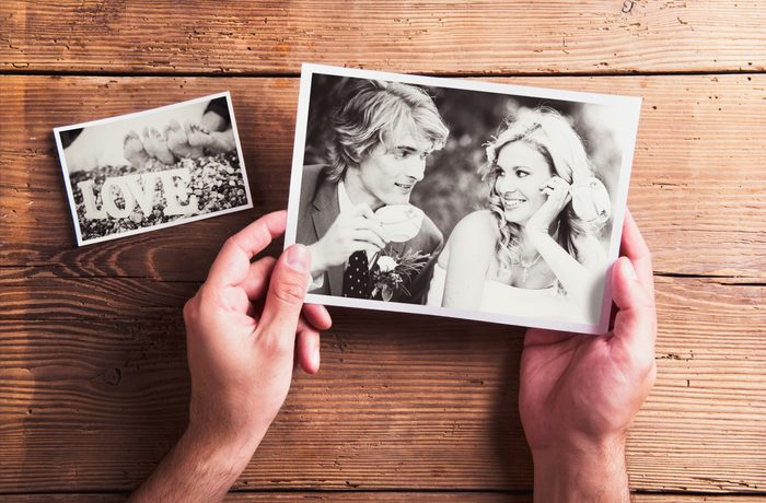 Wedding photos laid on a table. Studio shot on wooden background.