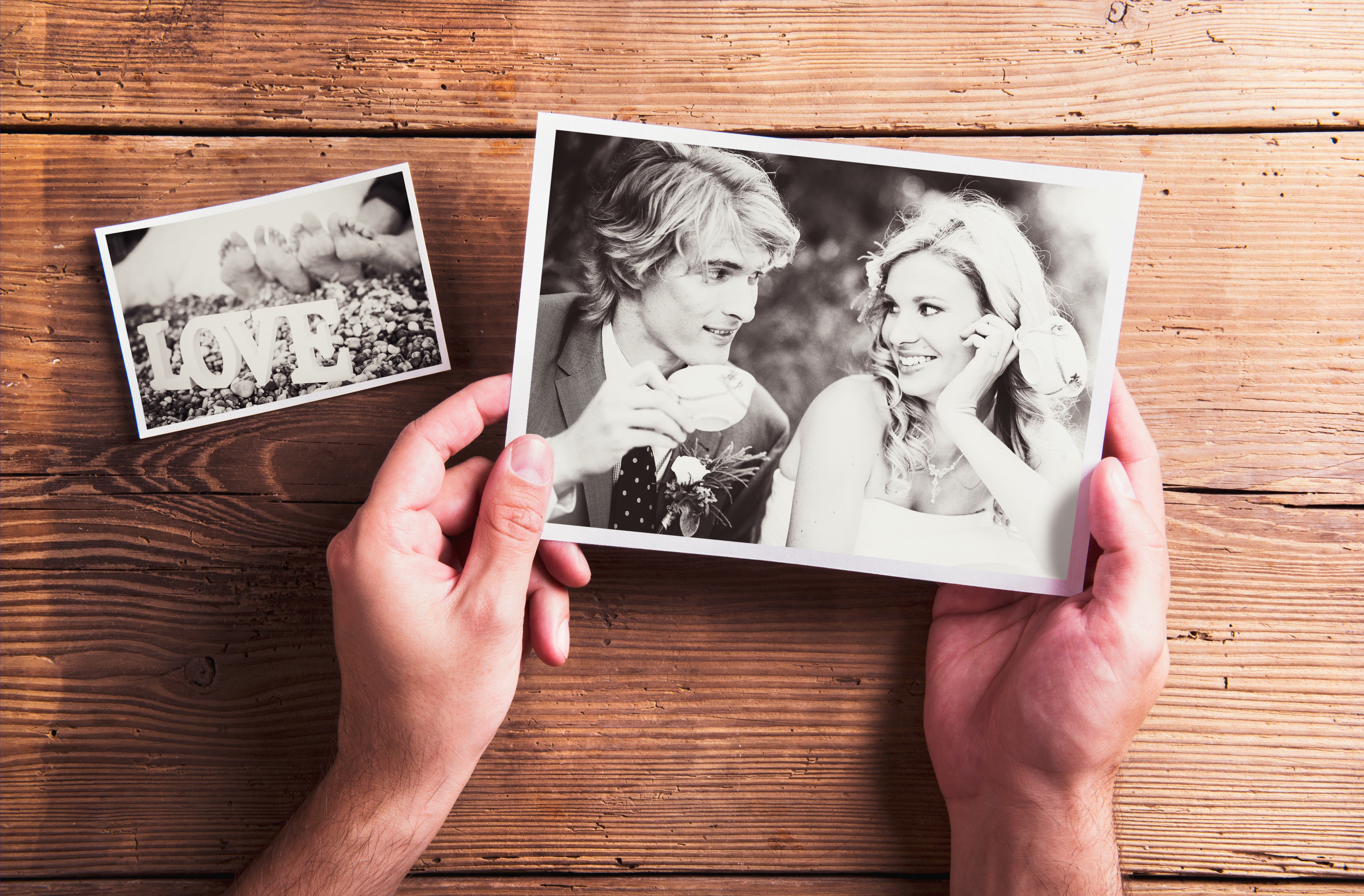 Wedding photos laid on a table. Studio shot on wooden background.