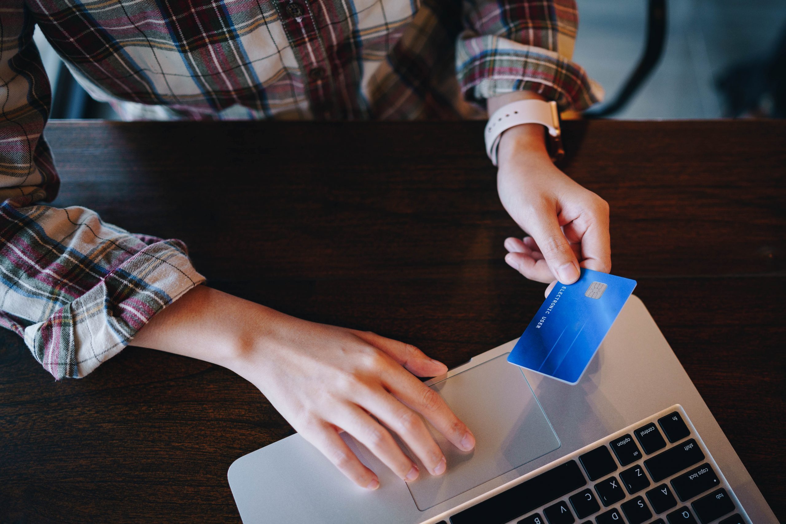 Woman's hands holding credit card and using laptop for shopping online. Pays for purchase. Shopping online concept.