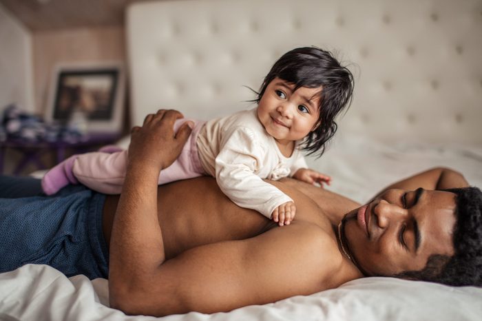 nice girl lying on her cheerful father, side view photo