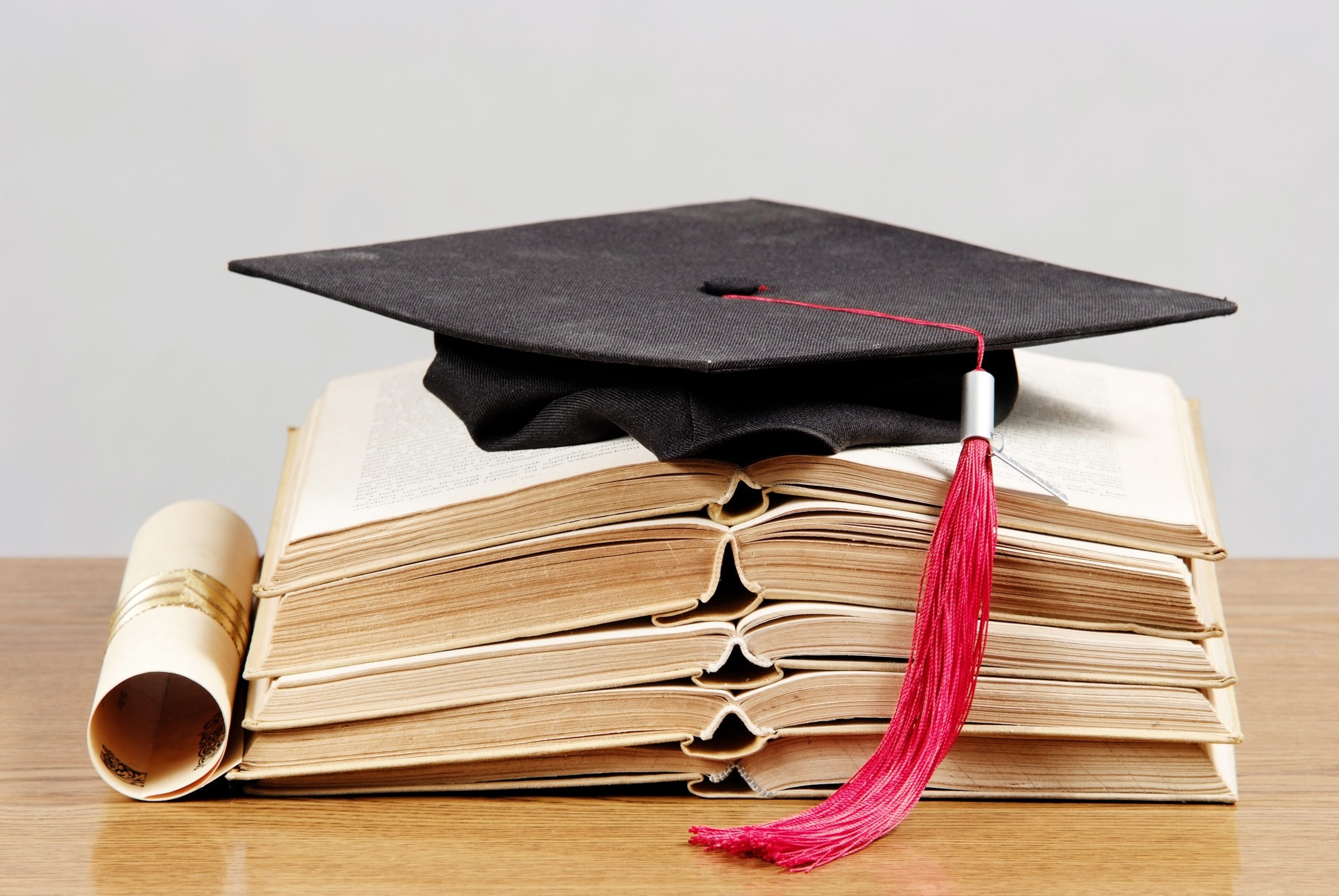 Graduation cap with book and diploma