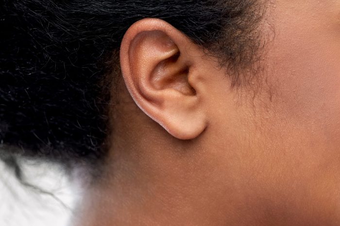 health, people and hearing concept - close up of young african american woman ear