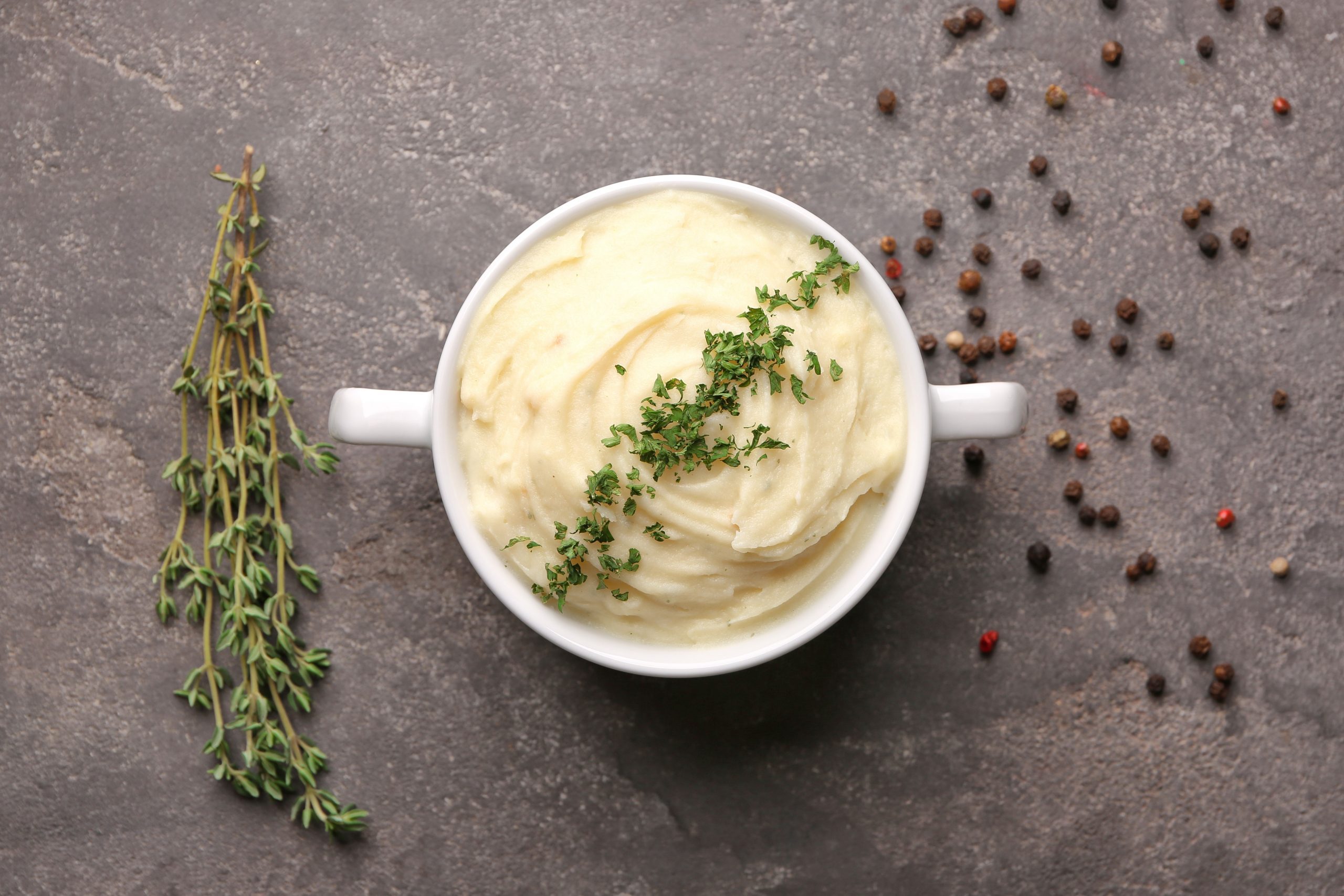 Dish with mashed potatoes on grey background