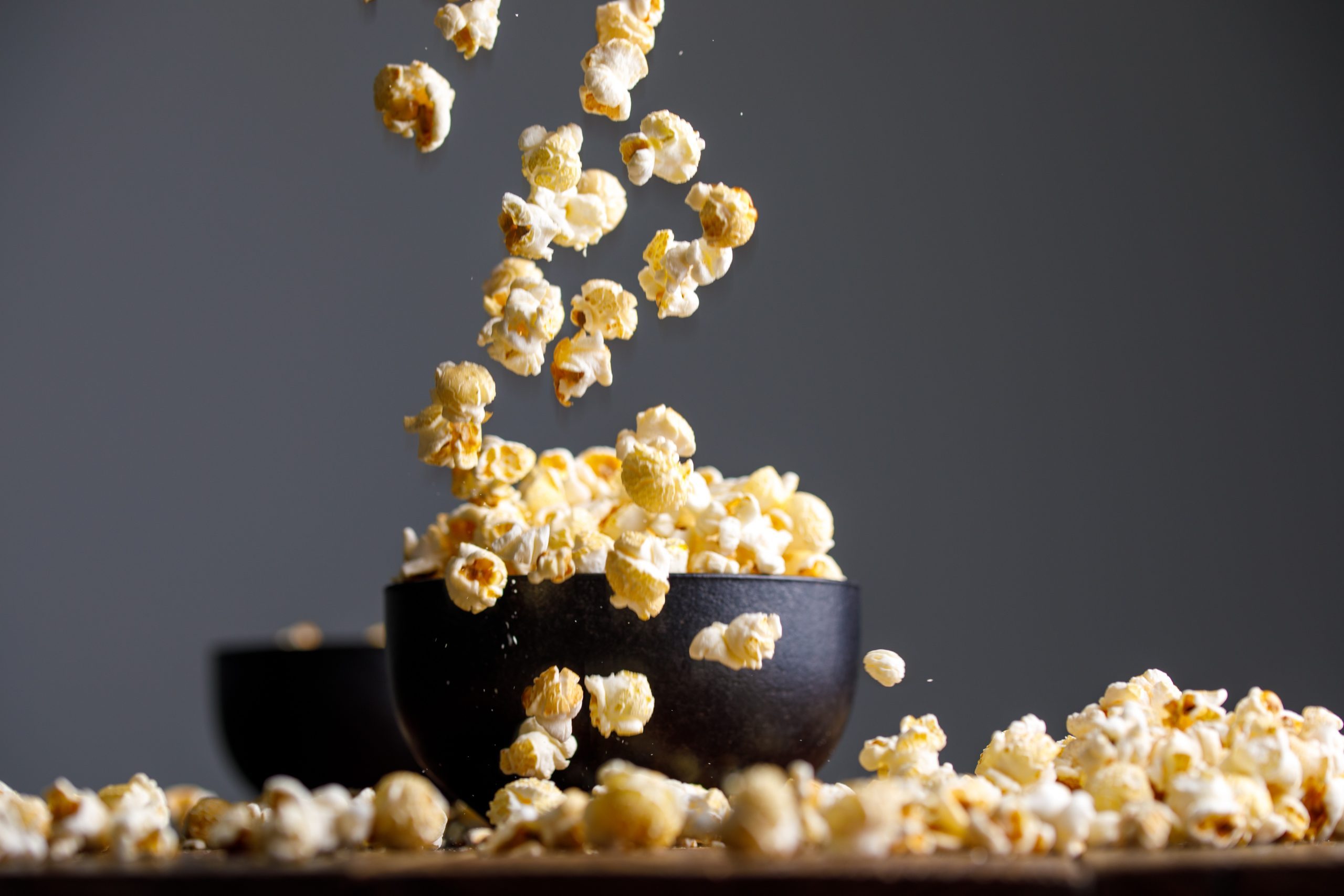 Levitating popcorn around a ceramic bowl. Appetizing still life.