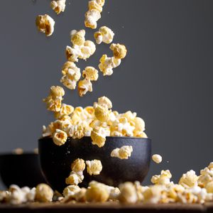 Levitating popcorn around a ceramic bowl. Appetizing still life.