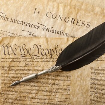 The Constitution for the United States of America with a quill pen