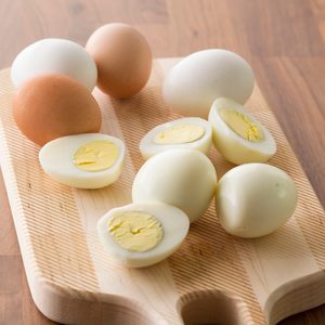 Peeled and halved hard boiled eggs laid out on a cutting board