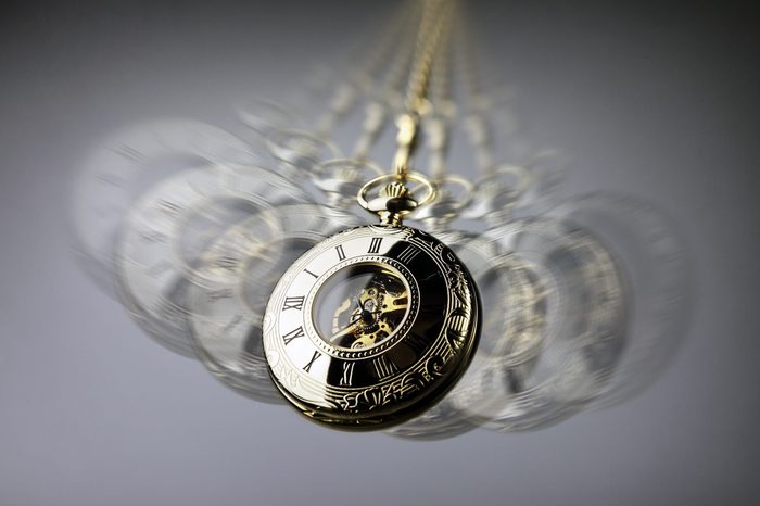 Hypnotism concept, gold pocket watch swinging used in hypnosis treatment