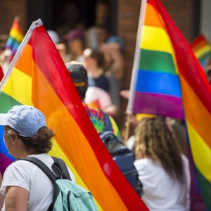 People with rainbows flags in the annual Pride Parade as it passes through Greenwich Village.