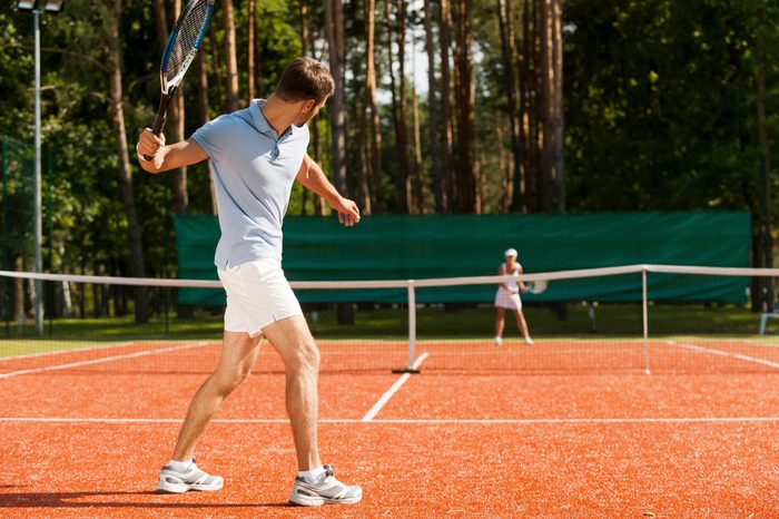 Practicing with friend. Full length of man and woman playing tennis on tennis court