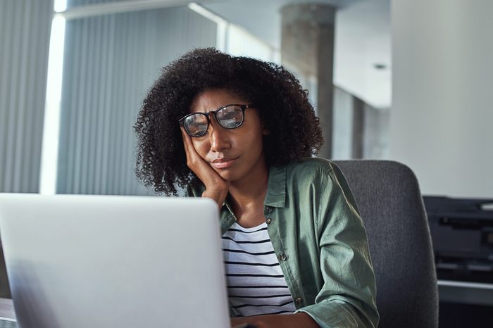 Stressed frustrated young businesswoman looking at laptop