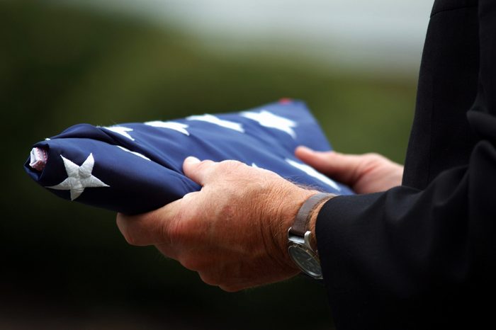 Man's hands holding a folded American flag