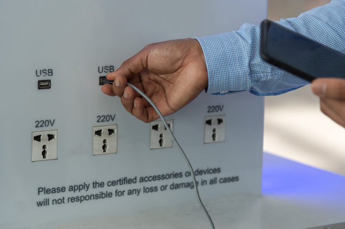 Charging mobile battery station in public area. Cellphone plug of electric power adapter in airport hall for all passengers. Free charger for devices. Copy space.