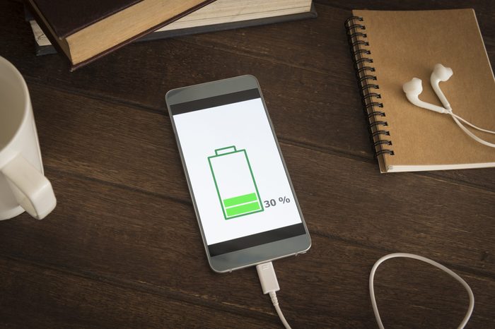 Mobile smart phones charging on wooden desk