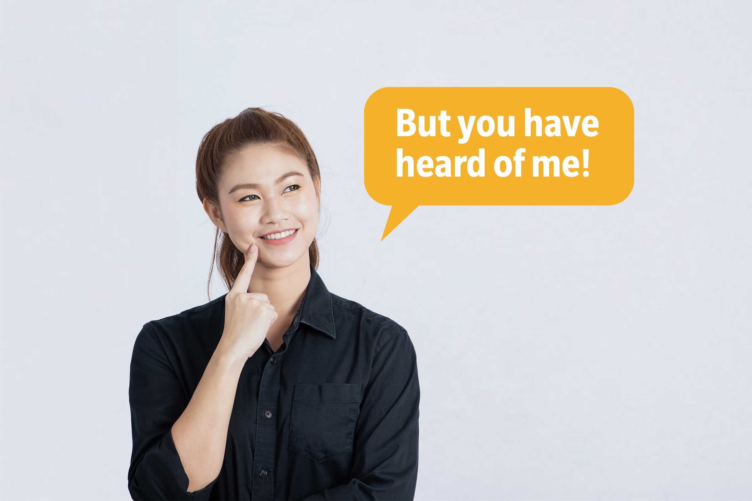 Smiling woman with finger on chin delivering a comeback roast, speech bubble text: "But you have heard of me!"