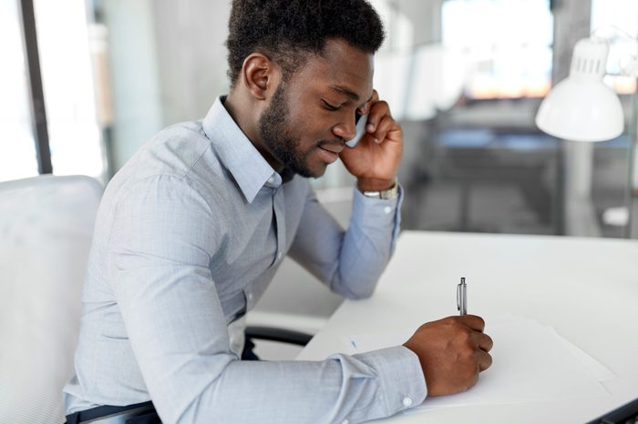 business, people, communication and technology concept - smiling african american businessman with papers calling on smartphone at office