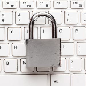 padlock and white computer keyboard on the wooden office table. privacy protection, encrypted connection concept