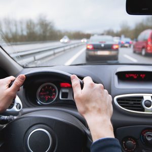 driving car on highway, close up of hands on steering wheel