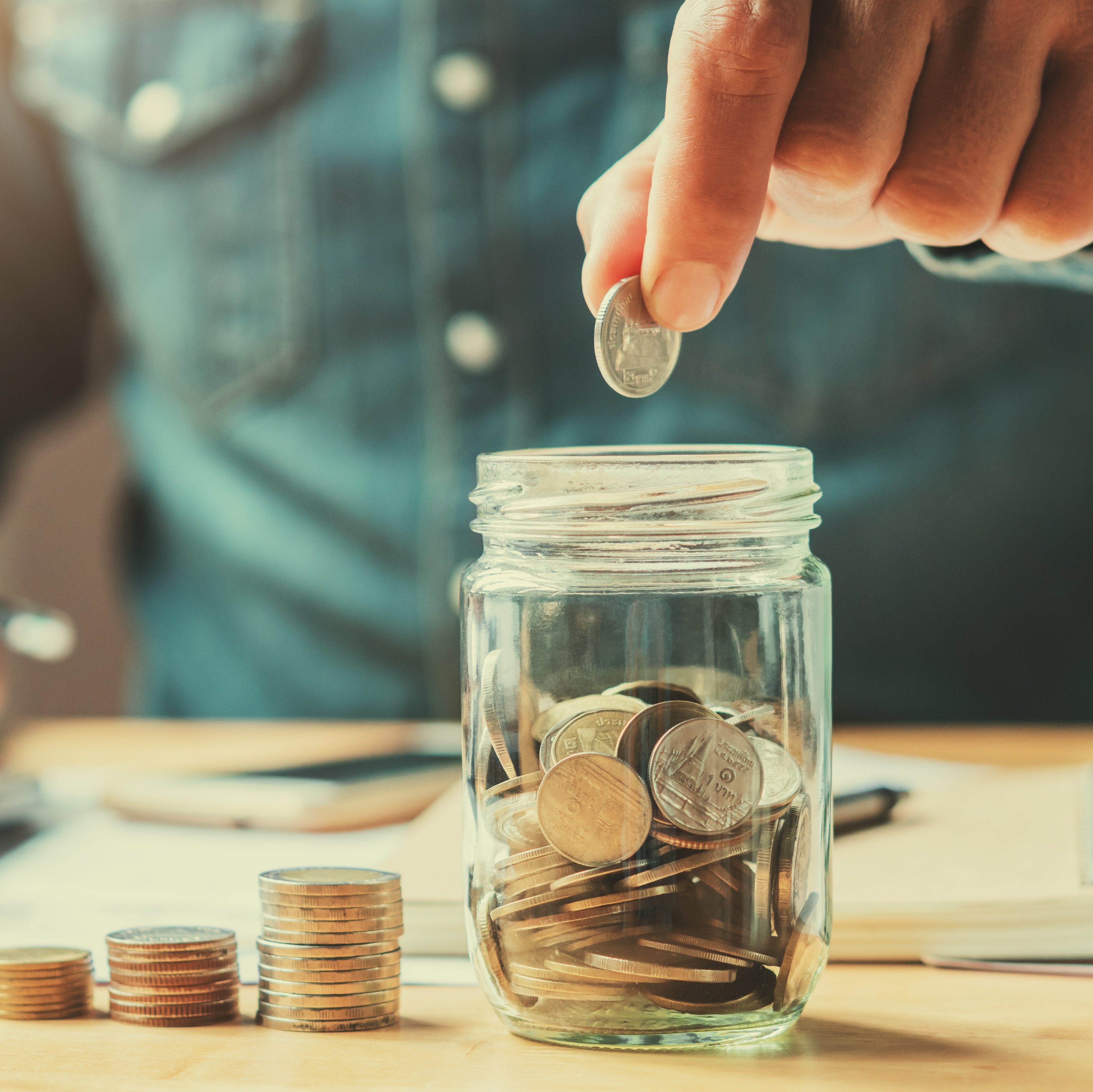 businessman holding coins putting in glass. concept saving money for finance accounting