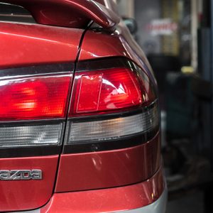 Bangkok, Thailand 14 May 2018 : Tail lights of red car that being repaired in a garage