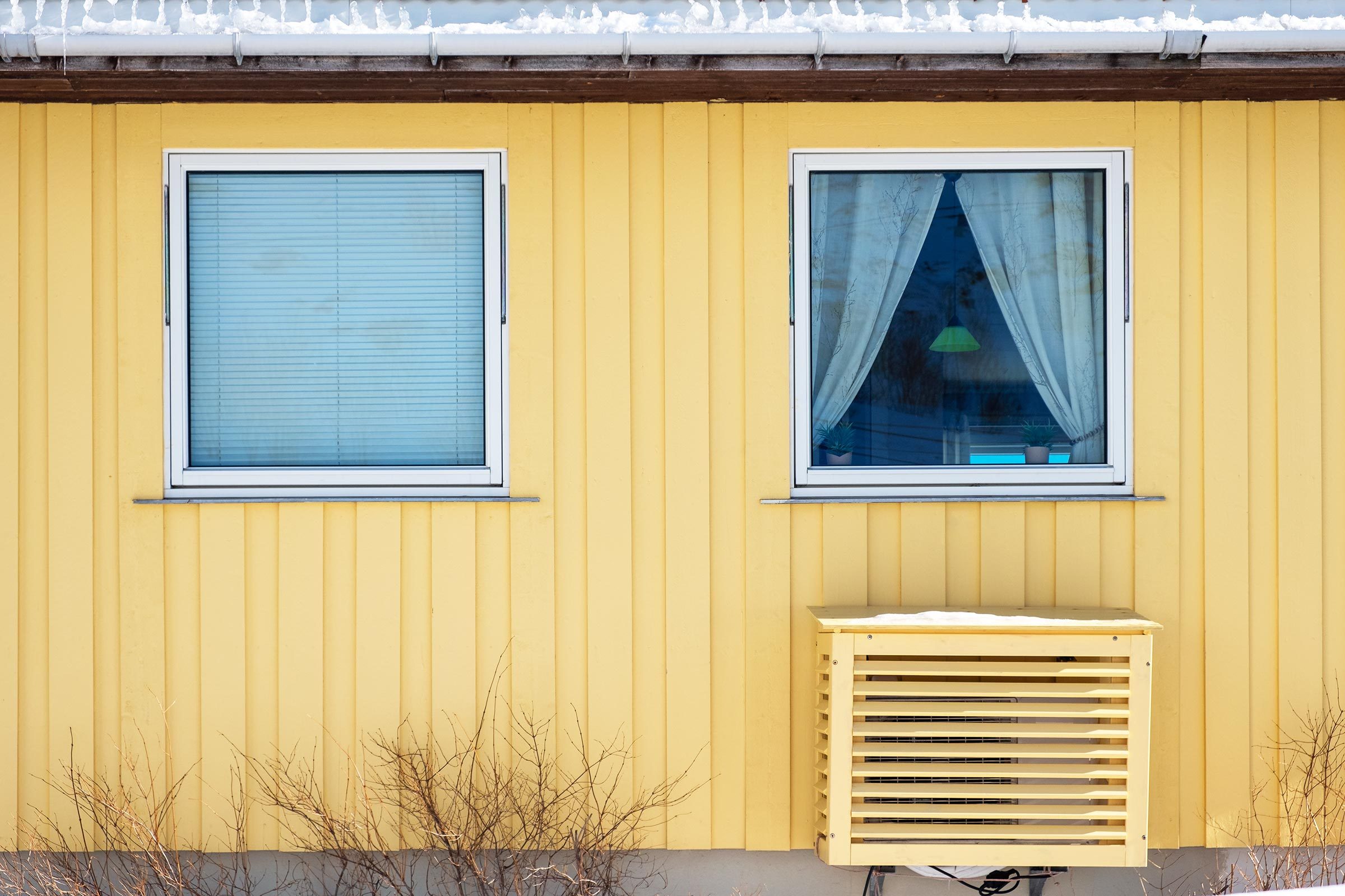 Exterior of Yellow hardwood wall with windows at side of house