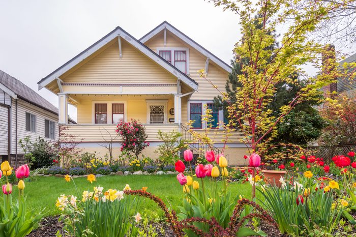 Beautiful exterior of newly built luxury home. Yard with green grass and walkway lead to front entrance.