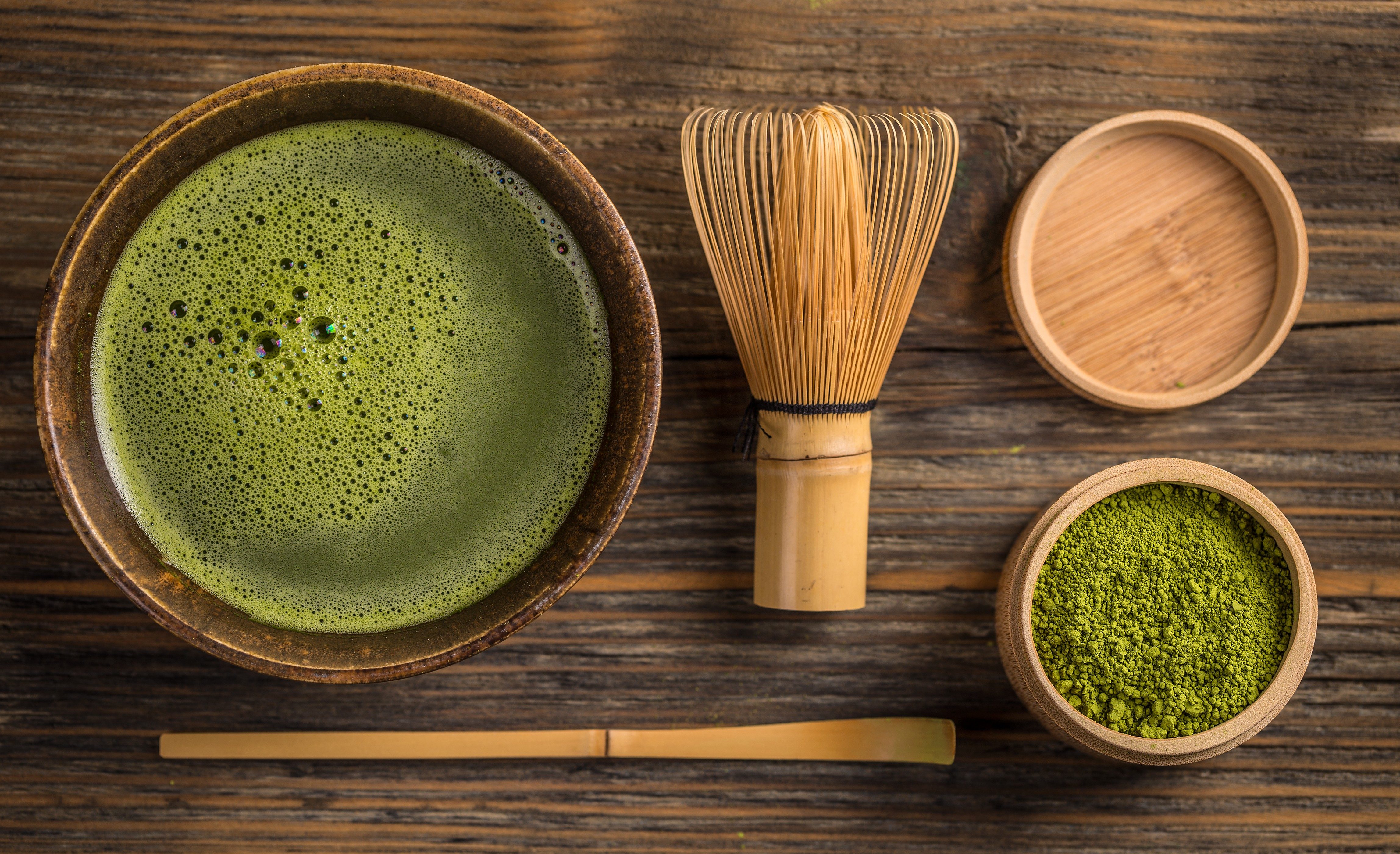 Top view of green tea matcha in a bowl on wooden surface