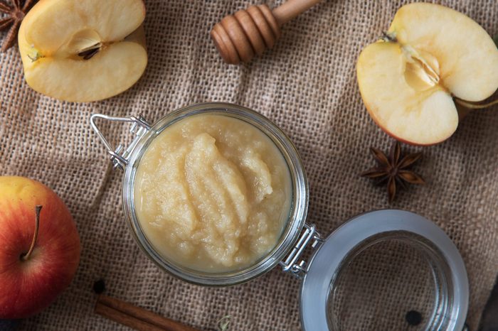 Fresh homemade applesauce with apples on a wooden table