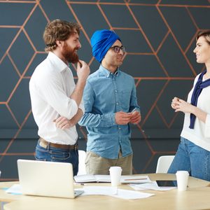 Intercultural men interviewing young female in studio
