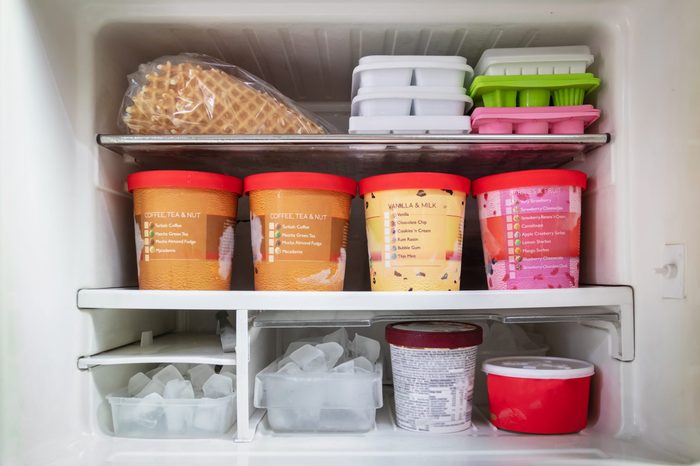 Full of bucket container ice creams flavors and ice cubes in freezer get ready for summer.